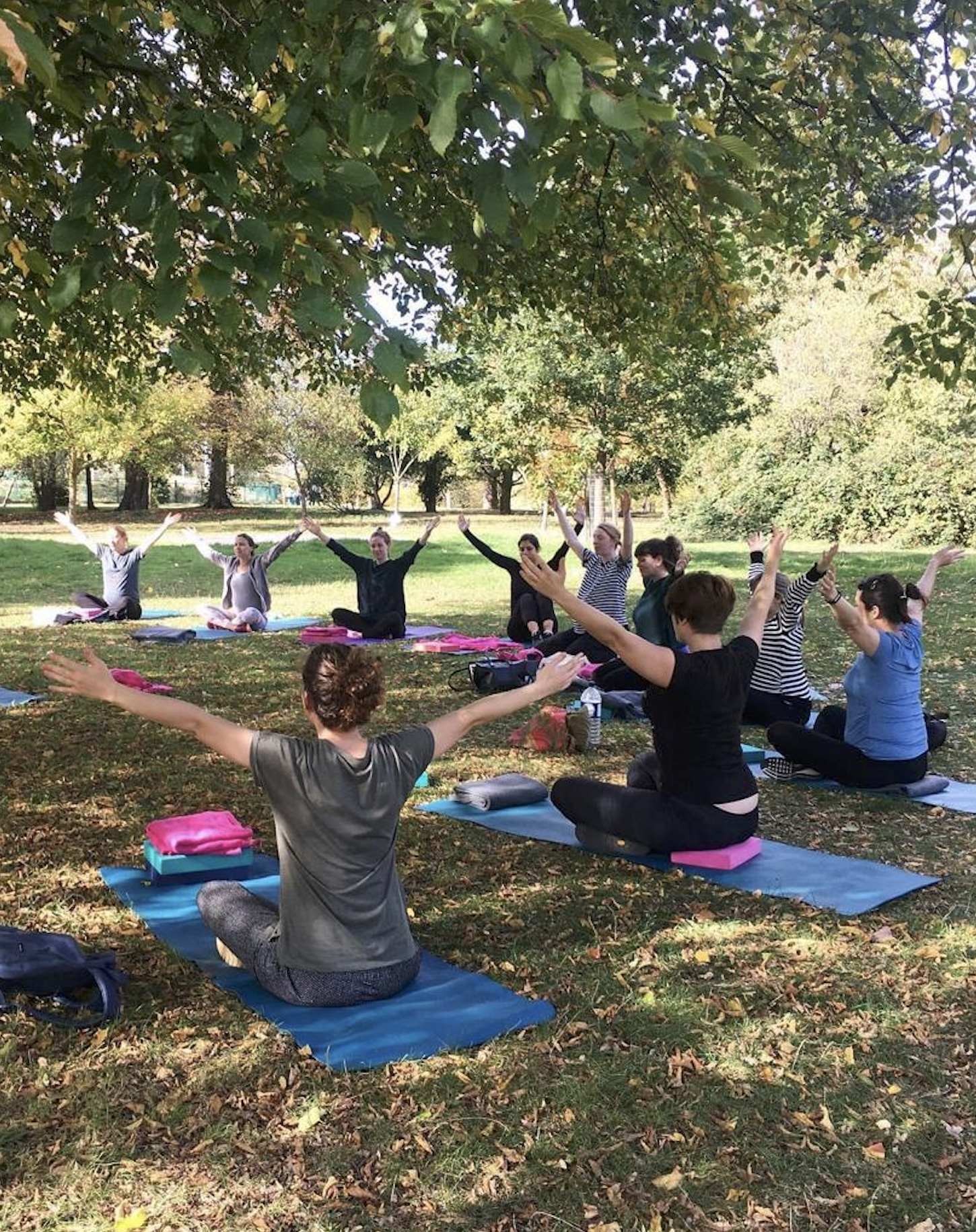 How to start teaching yoga — yoga teacher training students practising outdoors in London